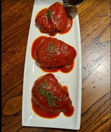 Albóndigas en salsa de tomate en una fuente blanca.